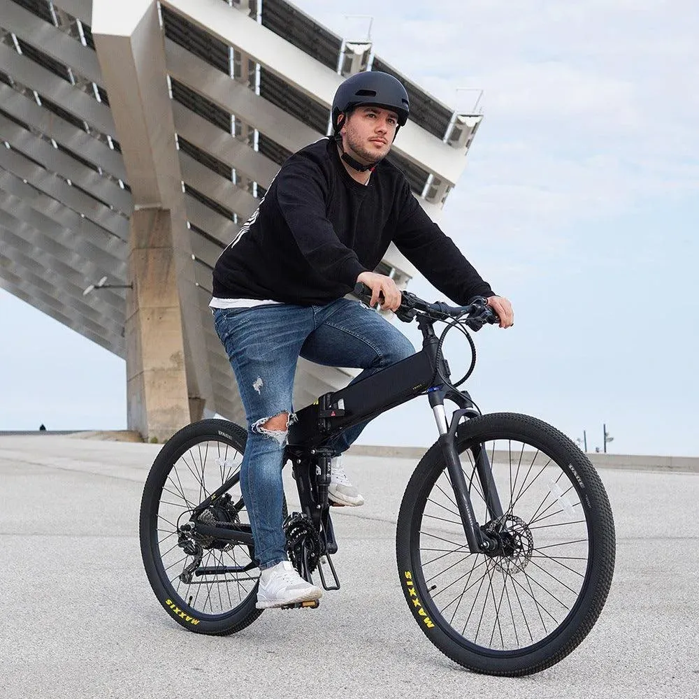 Cycliste casqué sur un Legend Etna noir, sur une esplanade en béton au bord de la mer